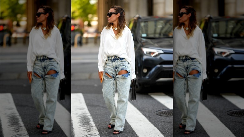 Woman wearing light-wash jeans with cutouts