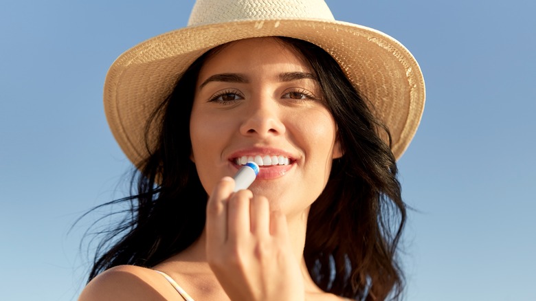 woman applying SPF lip balm