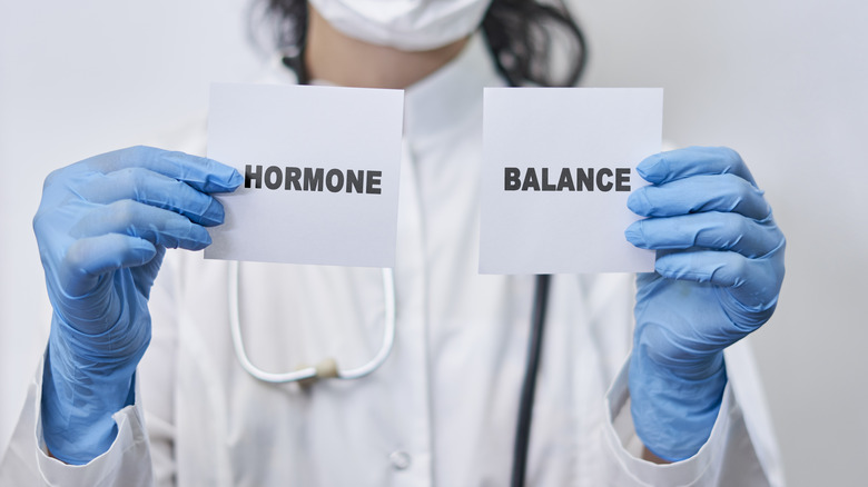 A doctor holding hormonal balance papers