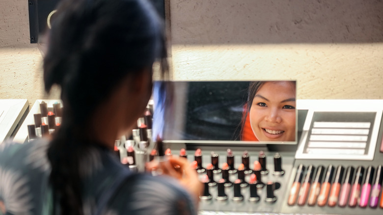 A woman picking out lipstick