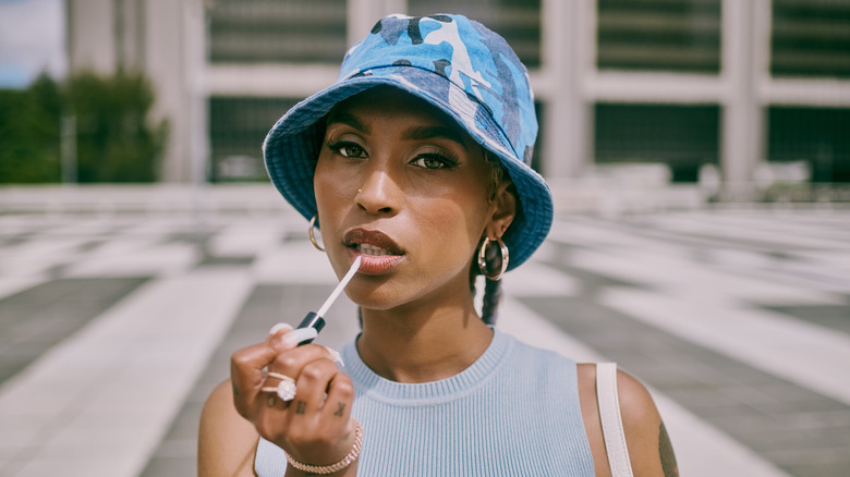 woman applying lip oil 