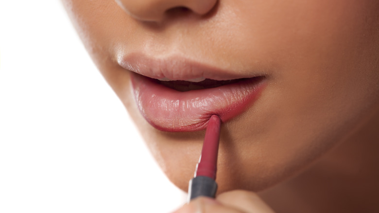 Woman putting on a lip liner