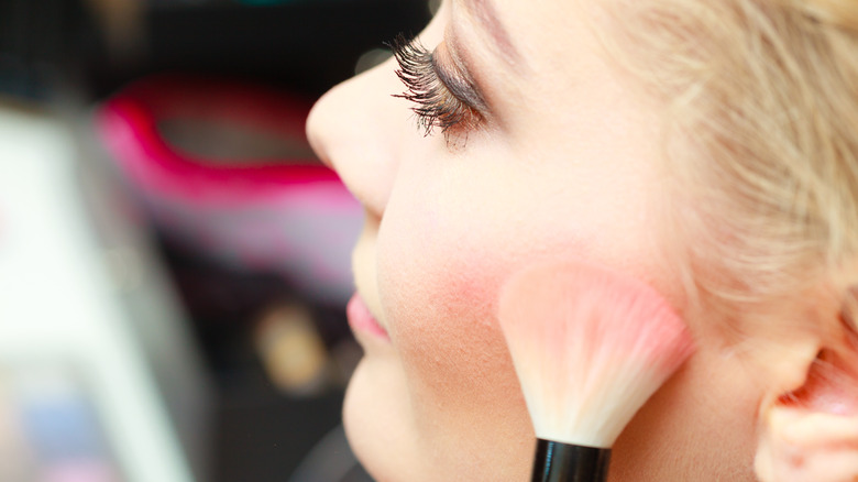 Applying blush with brush