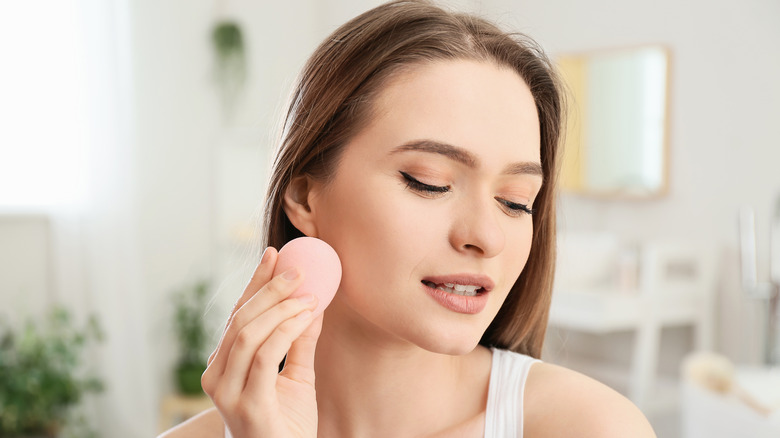 woman using makeup sponge