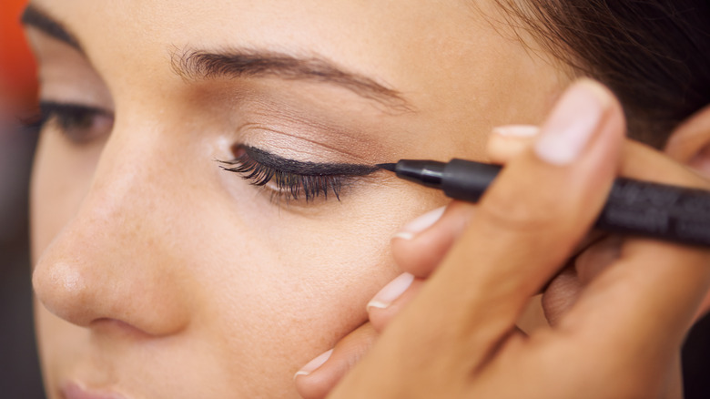 Woman applying eyeliner