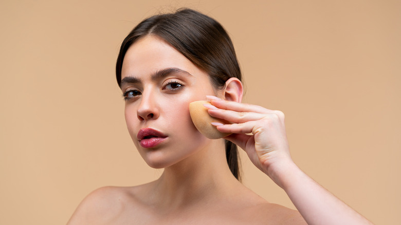 Woman using sponge with liquid highlight