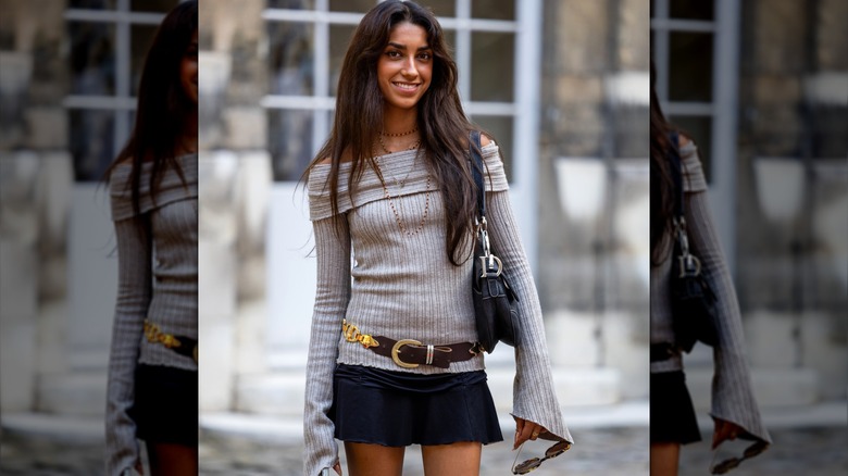 Woman wearing belt over gray sweater