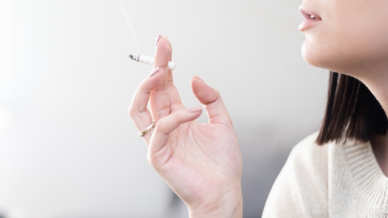 Woman holding a lit cigarette