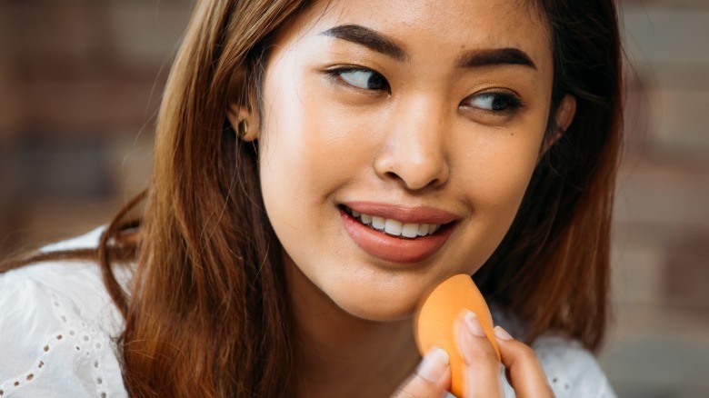 Woman holding a beauty sponge