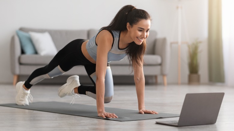 Woman exercising and watching computer