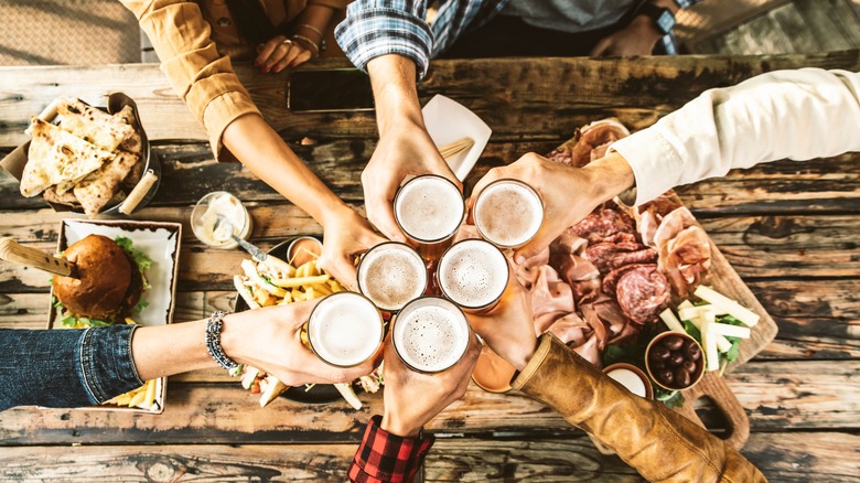 adults toasting drinks around a dinner table