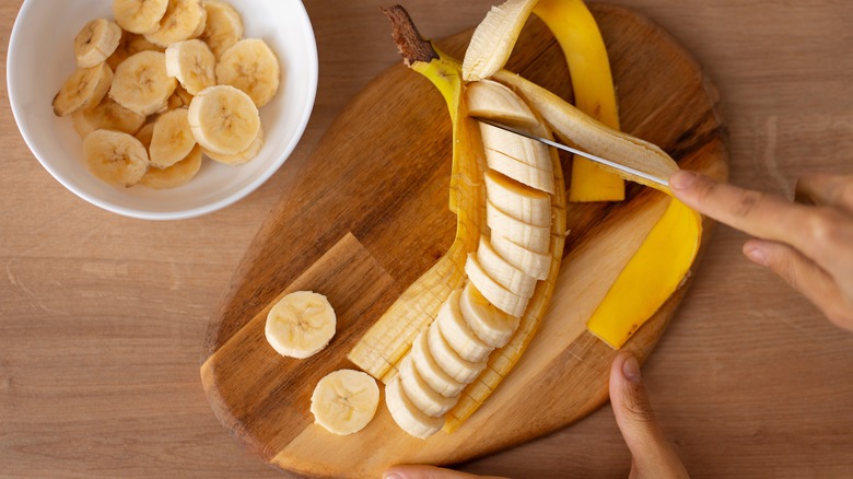 A banana being cut in its peels