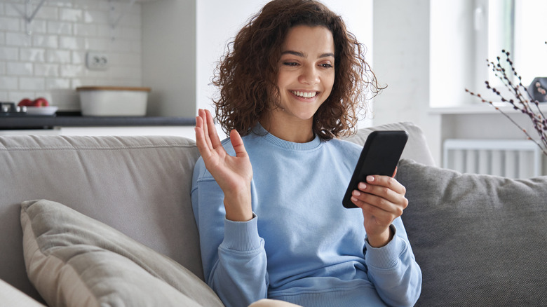 woman waving at phone