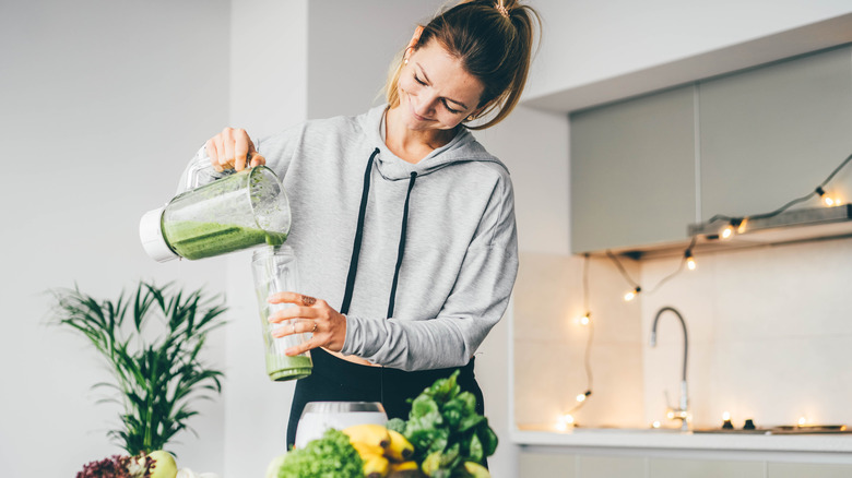 woman pouring green smoothie