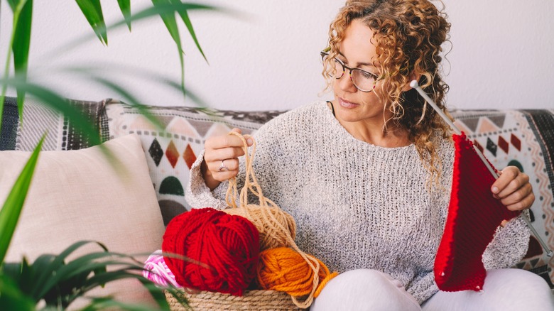 woman knitting on couch