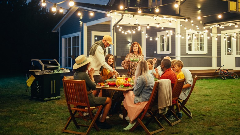 friends having dinner party in backyard