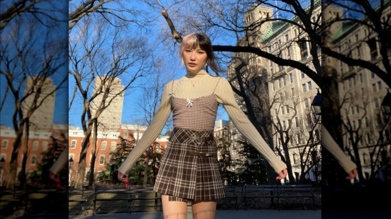 Woman wearing checked top and plaid skirt