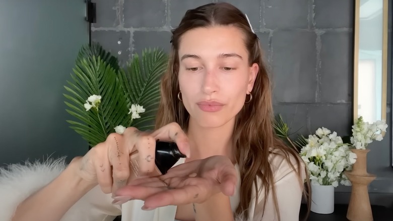 Hailey Bieber pumping foundation into hand