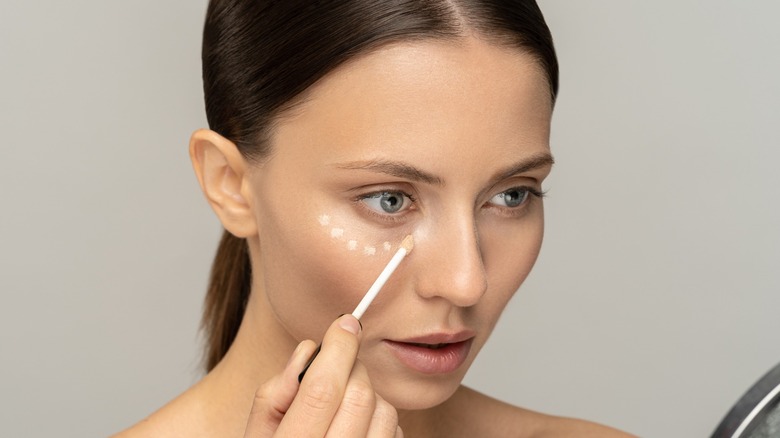 Woman applying concealer