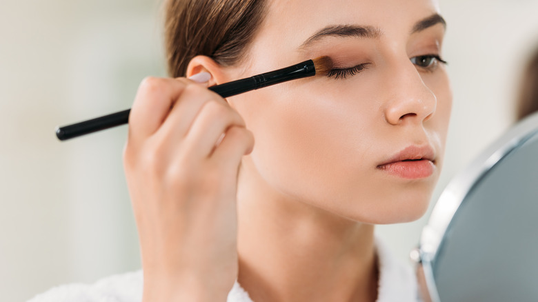 A woman applying eyeshadow