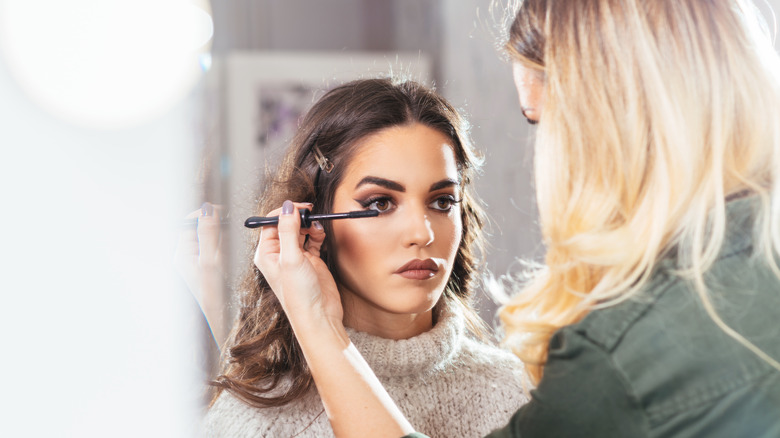 A woman getting her makeup done