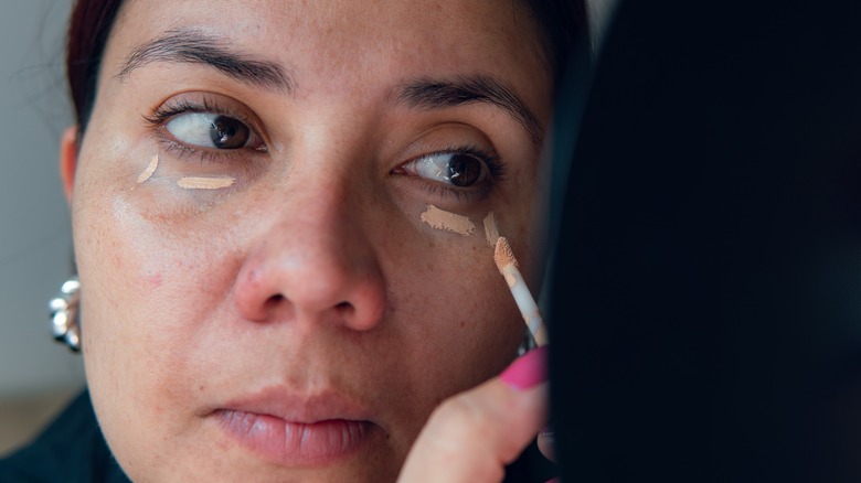 Woman applying concealer