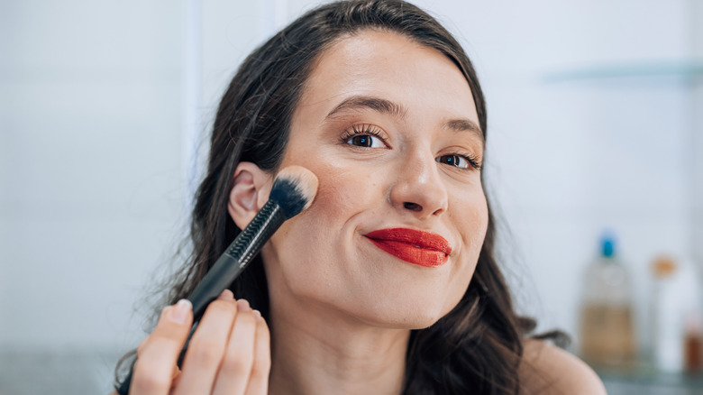 Woman applying makeup with brush