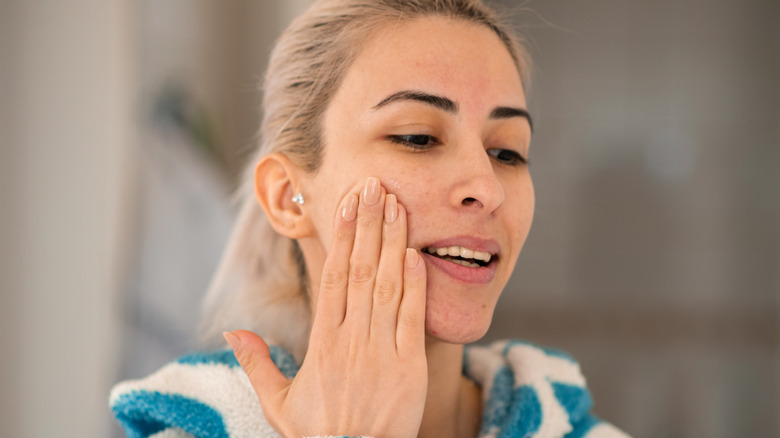 Woman cleansing face over sink