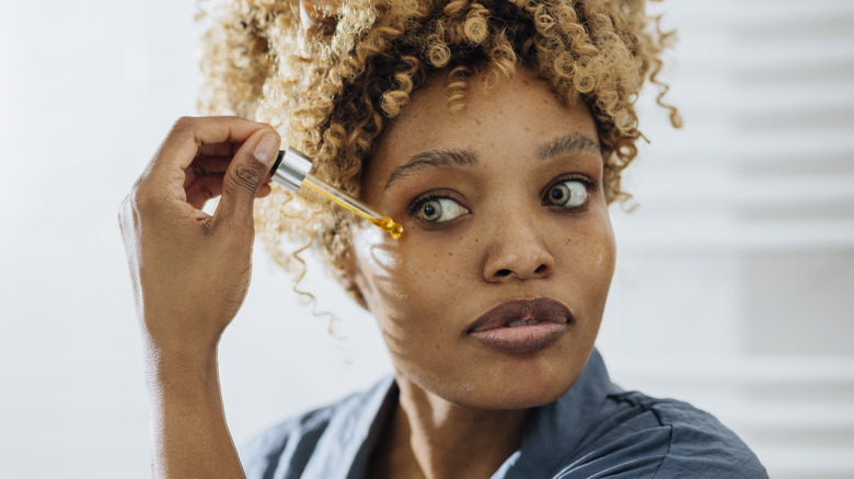 Woman applying face serum