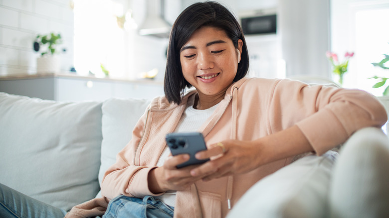 Woman smiles while using cell phone