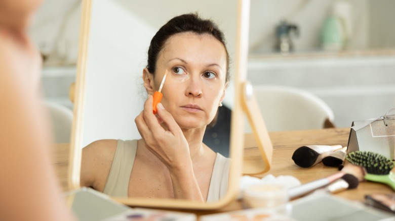 Woman applying concealer