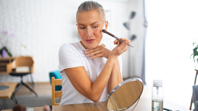 Woman applying makeup with a brush