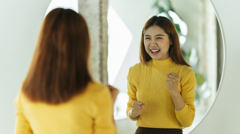 Asian woman smiling in mirror