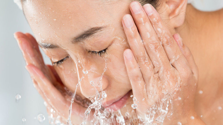 woman cleanses her face