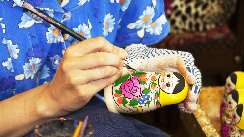 Woman paints Russian nesting doll 