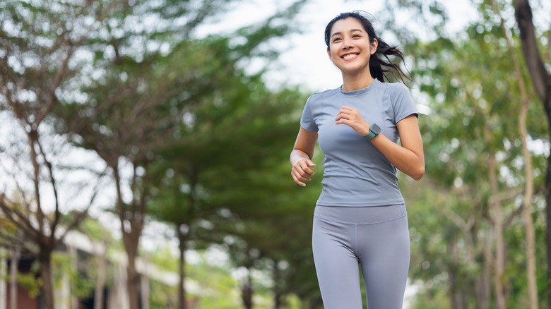 Woman jogs outdoors with a smile