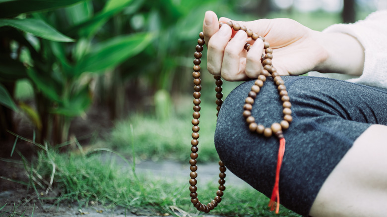 Person meditating with mala beads