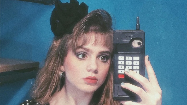 Girl with short mall bangs, big phone