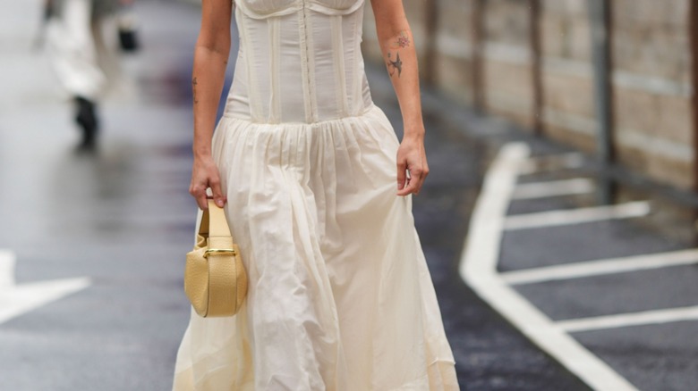 woman holding margarine yellow purse