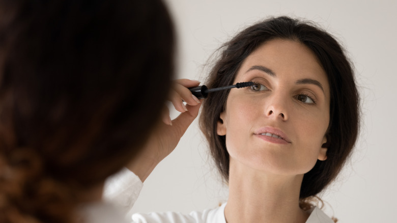 Woman applying mascara