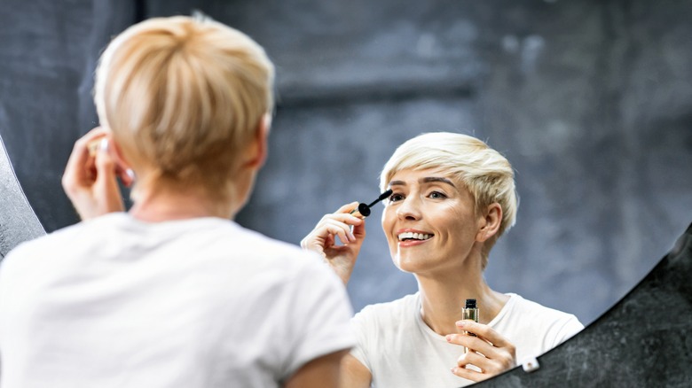 Woman with short hair applying mascara