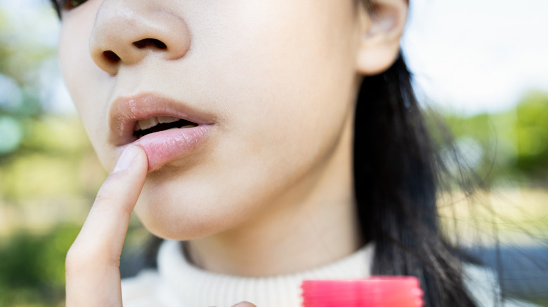 Woman applying lip balm