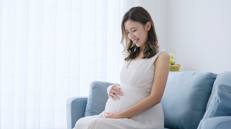 smiling pregnant woman on sofa
