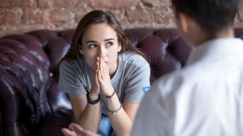 Woman looks uneasy as man speaks