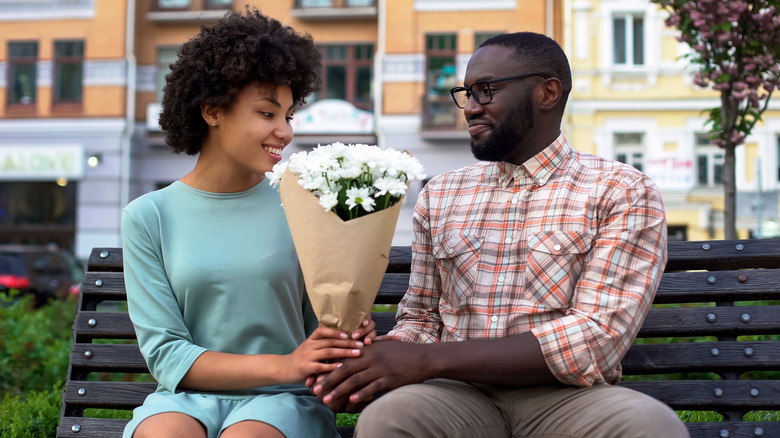 Man giving woman flowers