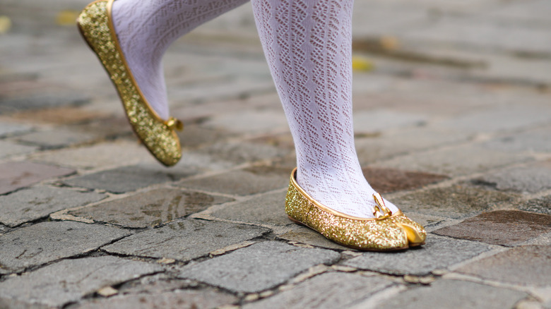 woman wearing gold metallic flats