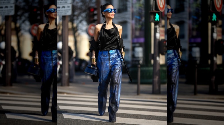 woman wearing black top and blue/black textured metallic pants