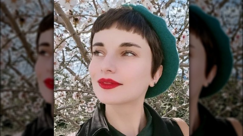 person with micro bangs and hat
