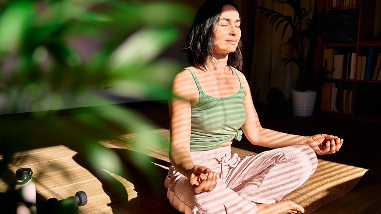 Woman meditates in sunny room