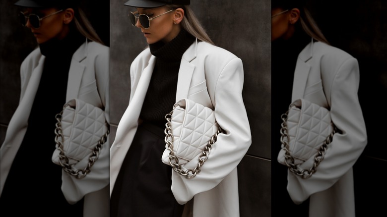 Woman holding white handbag with chains